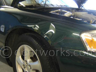 Green Mazda with minor dent
